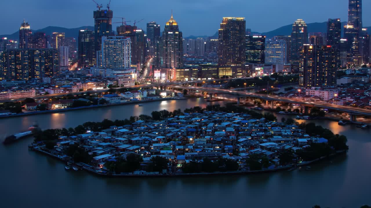 An aerial view showcases a small island in the river, covered with simple homes amidst a backdrop of towering skyscrapers.