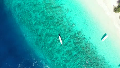 Indonesische-Boote-Für-Touren-Liegen-Auf-Dem-Türkisblauen-Wasser-Der-Lagune-Vor-Anker-Und-Waschen-Den-Weißen-Sand-Eines-Exotischen-Strandes,-Kopierraum