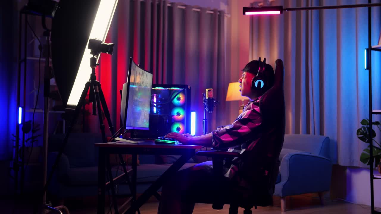 아시아 소년 스트리머의 측면 뷰 실망감을 느끼고 개인 컴퓨터에서 게임을 실패합니다. 라이브 스트리밍 비디오 게임, rgb led 스트립 라이트에 의해 조명 된 책상