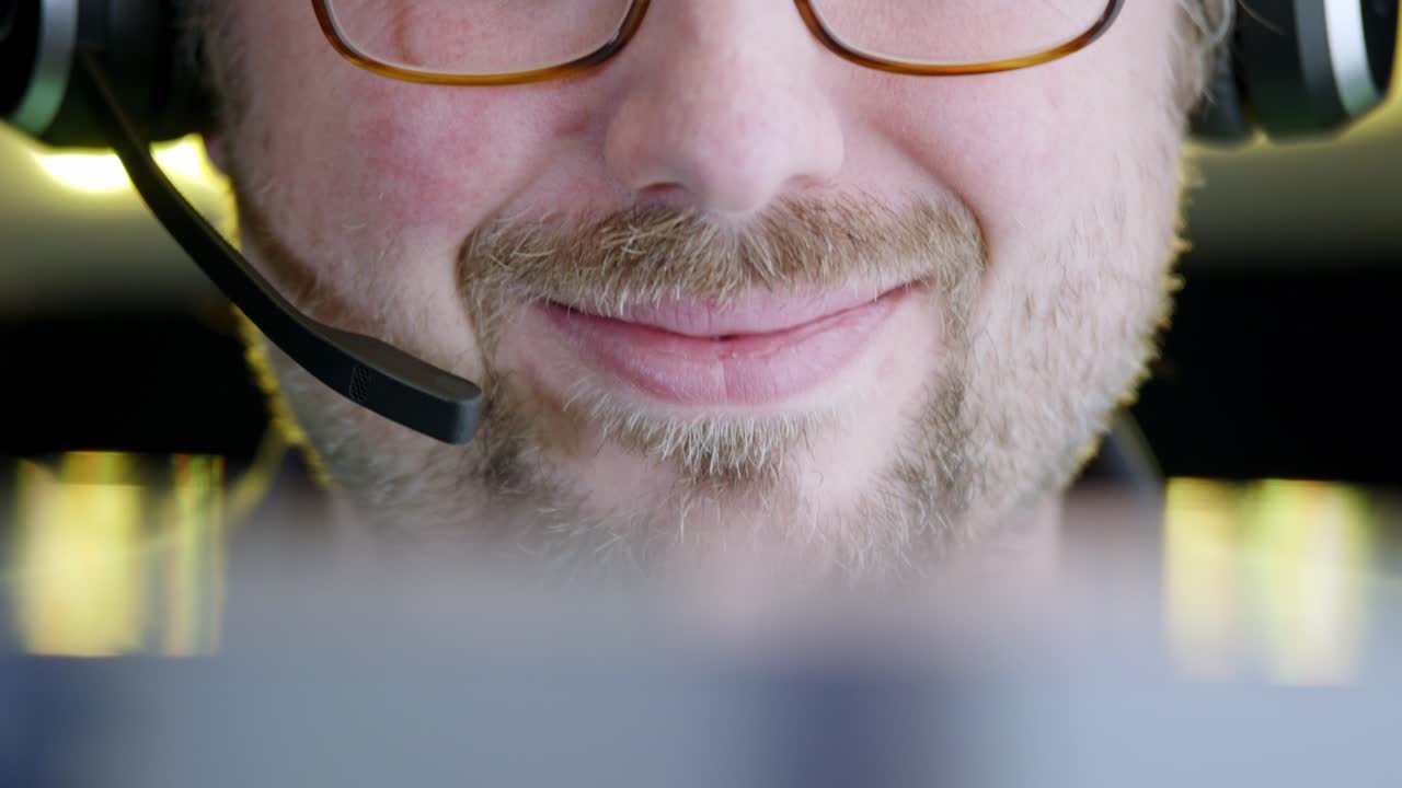 Caucasian man smiles and nods, listening with communication headset