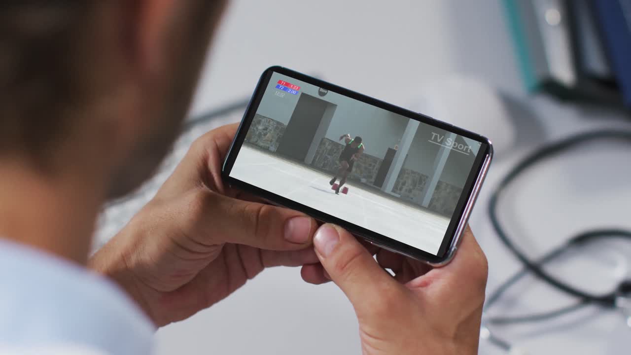 compuesto de un médico masculino viendo un evento de atletismo en un teléfono inteligente