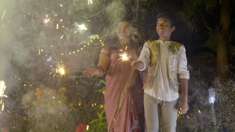 diwali celebrating a family family bursting firecrackers in diwali festival in india, mother and child enjoying with firecrackers