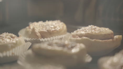 close up of cinnamon buns getting baked in the oven