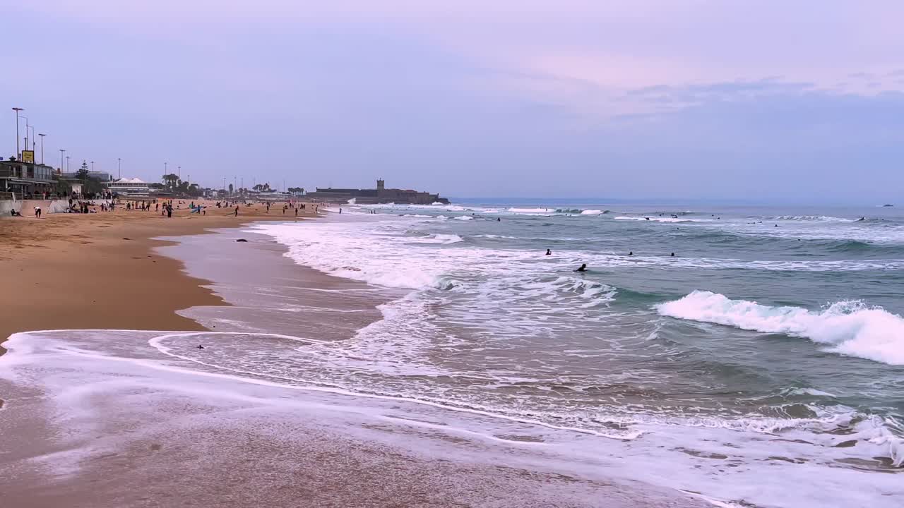 escenas de surfistas de todo el mundo que se unen para compartir su amor por el deporte y el océano en carcavelos