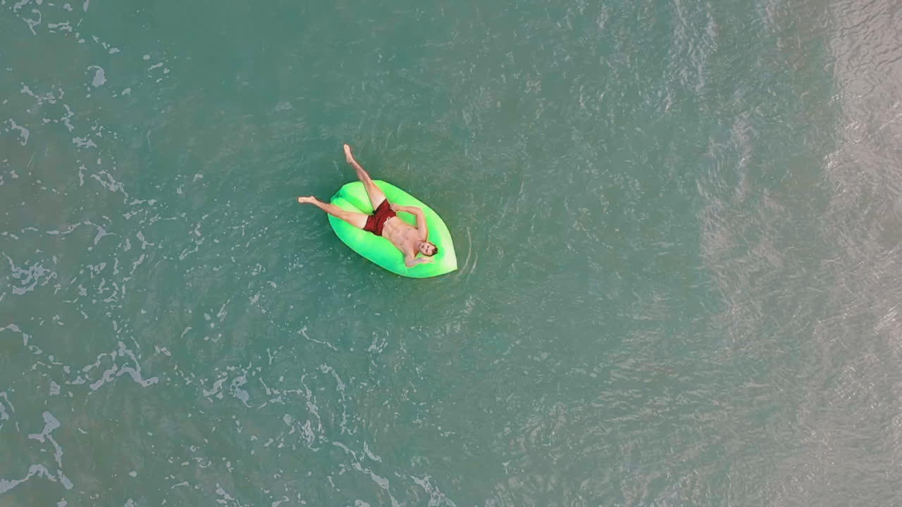 Man relaxing in turqoise water in the Philippines on vacation