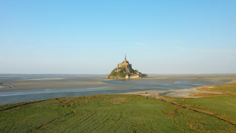 mont saint michel and its green meadows in europe, france, normandy, manche, in spring, on a sunny day.