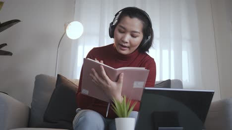 redshirt de mujer independiente usando tableta con auriculares para reunirse en línea en casa