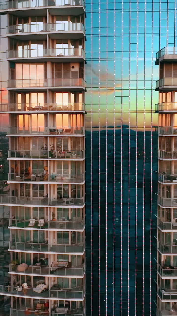 Drone aerial facade of glass building of a skyscraper. Evening reflections in the windows. Miami Vertical video