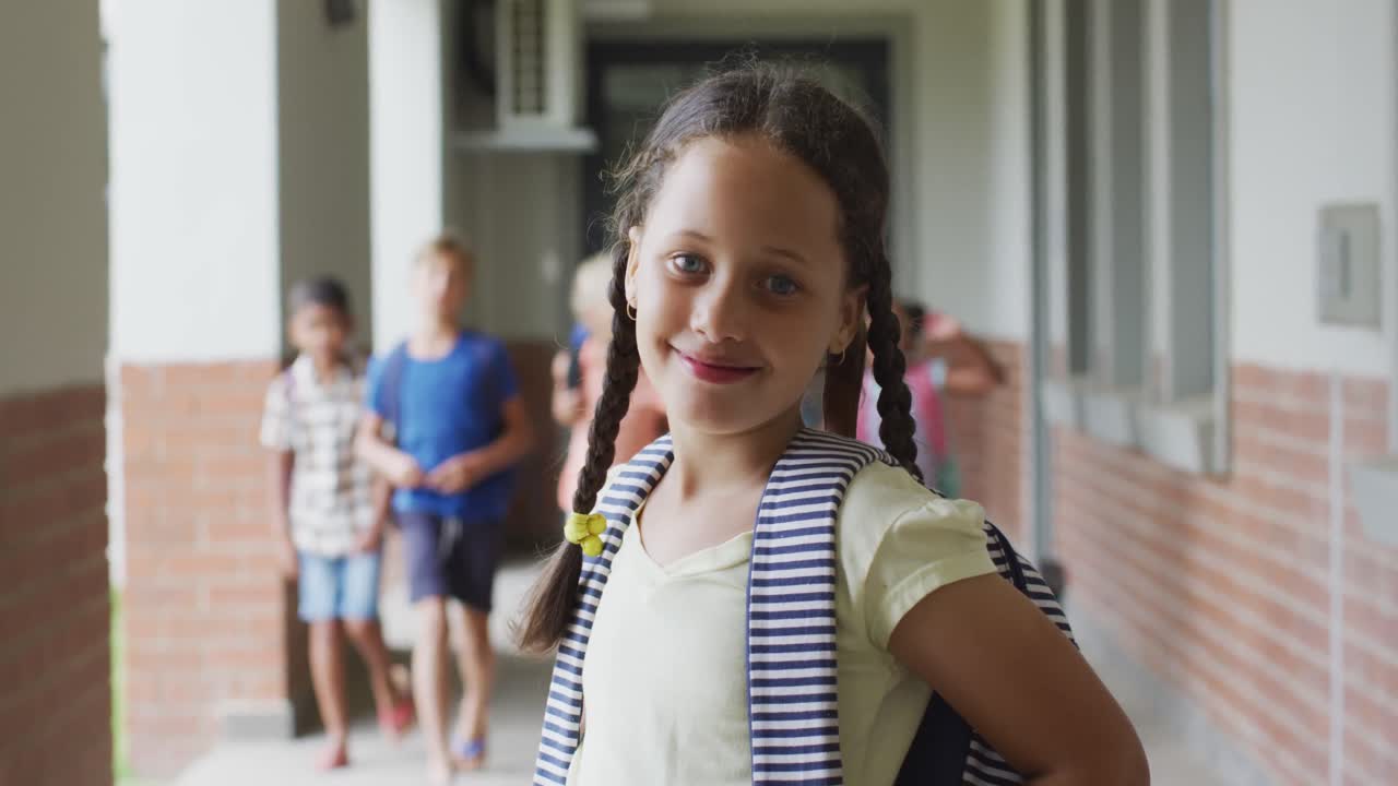 Vídeo de menina caucasiana feliz em pé no corredor da escola