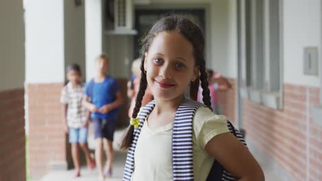 video de una chica caucásica feliz de pie en el pasillo de la escuela