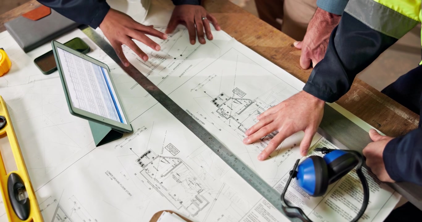 Architects and Engineers Reviewing Construction Blueprints on a Table
