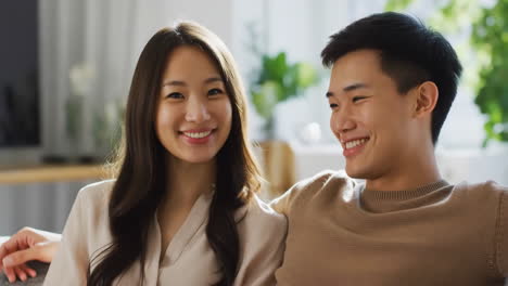 happy asian couple smiling and relaxing at home