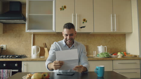 man reading a letter in the kitchen