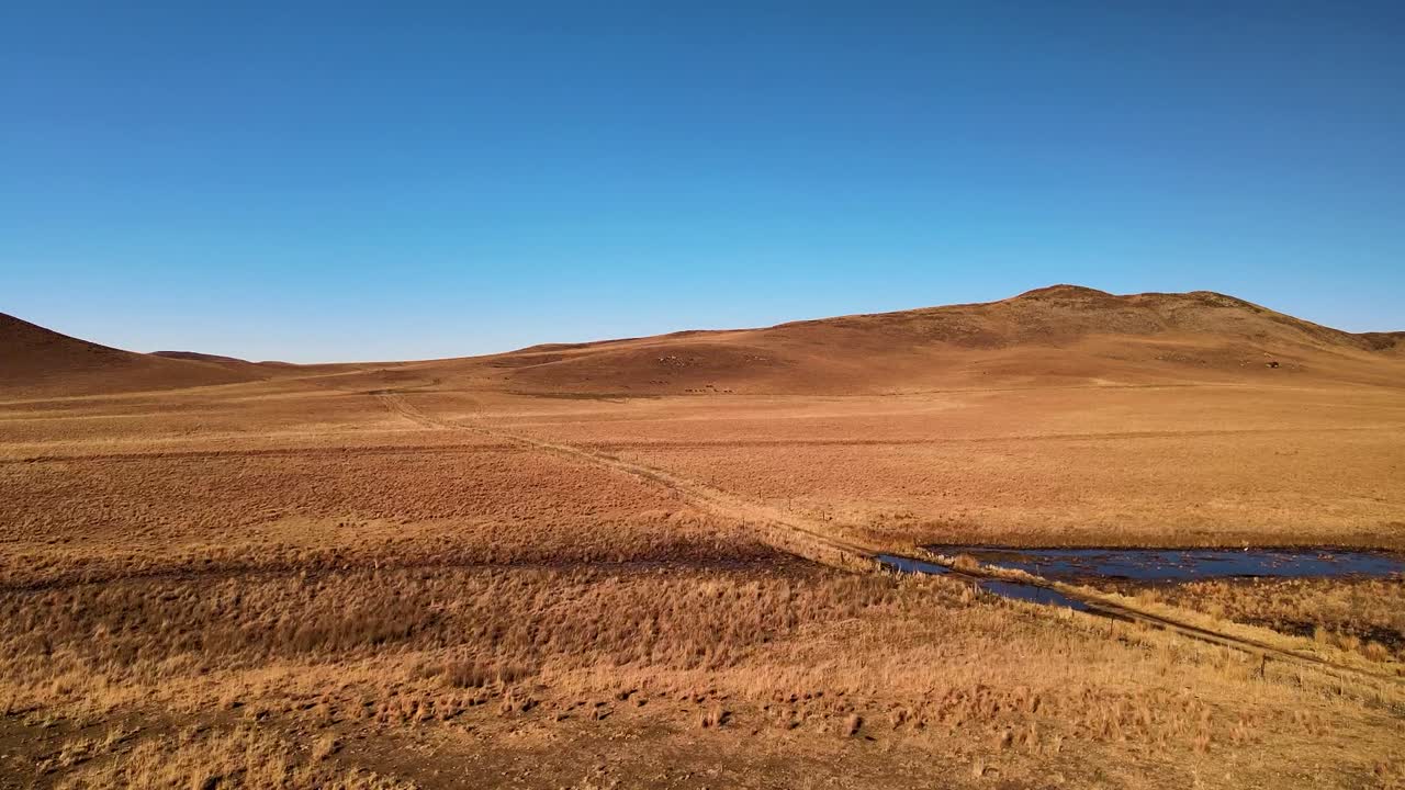 Windmill and Water Tank in a Dry Rural Landscape