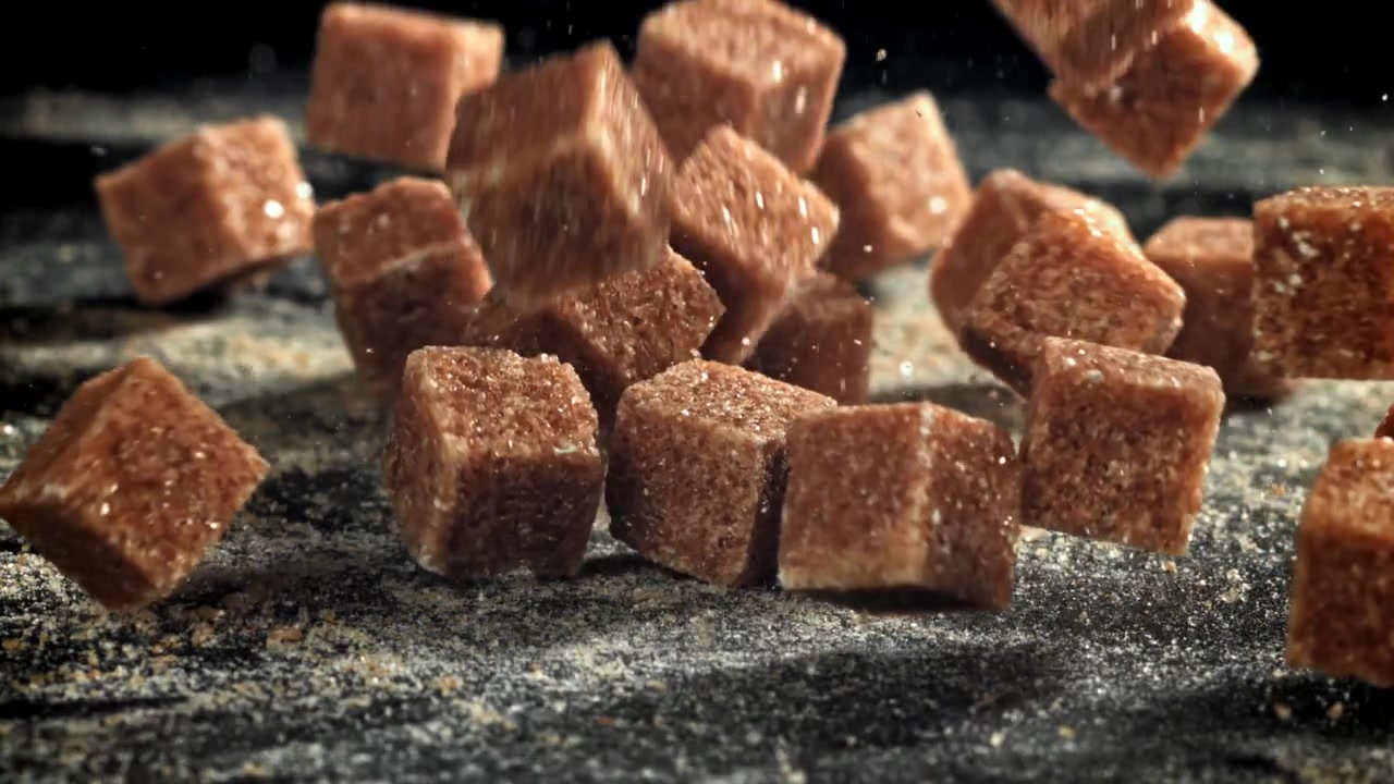 Brown Sugar Cubes Falling in Slow Motion on a Dark Surface