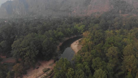 Vista-Superior-Del-Pequeño-Río-Cerca-De-La-Cueva-De-Konglor-En-Laos-Durante-La-Puesta-De-Sol,-Aérea