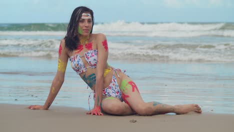 una soleada playa del caribe mostraba la belleza de una joven en bikini, su cuerpo adornado con una variedad de pinturas vibrantes