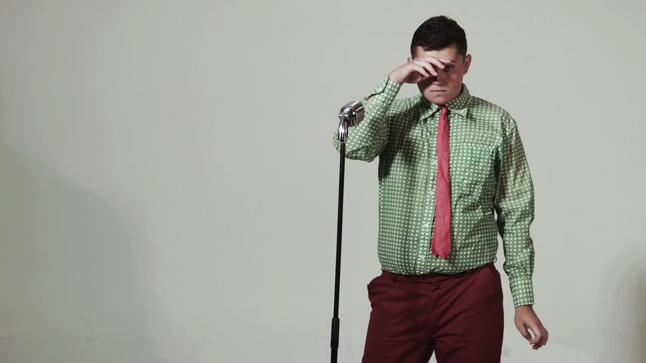 Young man singing passionately into a vintage microphone