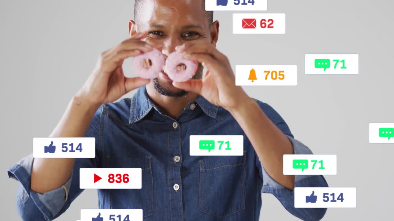 Uomo che divide a metà una ciambella rosa, sollevando le due metà agli occhi e mostrando icone di reazione dei social media.