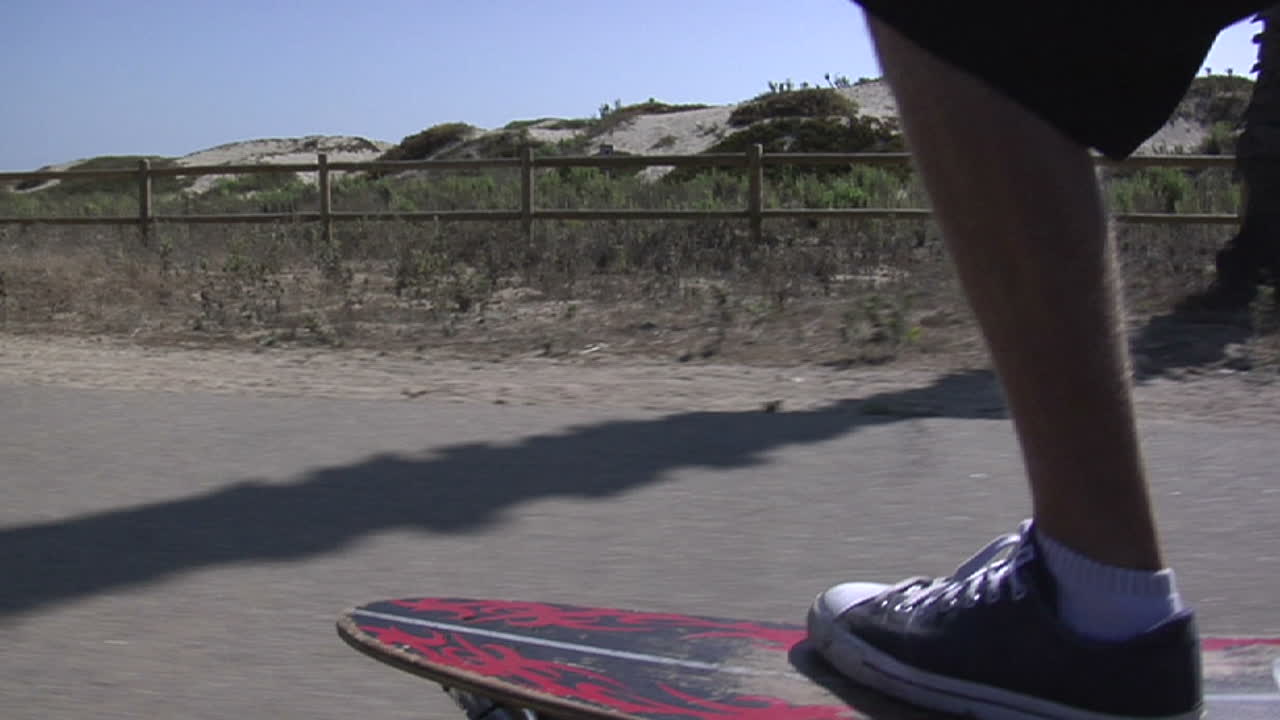 un patinador maniobra su camino a lo largo de una acera junto al mar