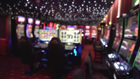 defocused casino interior full of slot machines and lights, panning left view
