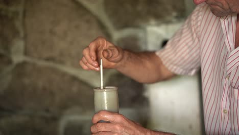 viticultor mayor colocando un hidrómetro de tubo de vidrio en un frasco de prueba lleno de jugo de uva