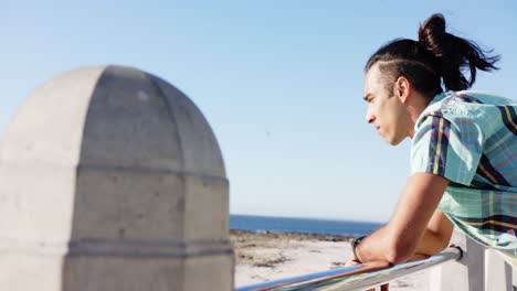 Happy-biracial-man-looking-away-at-promenade-by-the-sea,-slow-motion