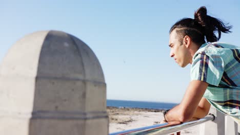 feliz hombre biracial mirando lejos en el paseo marítimo por el mar, cámara lenta