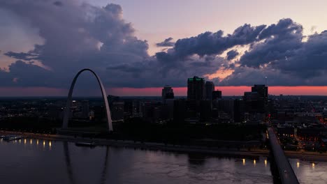 hyperlapse shot of the st. louis city skyline at sunset with storm clouds moving in. rain can be seen in the background against the scenic pink sky