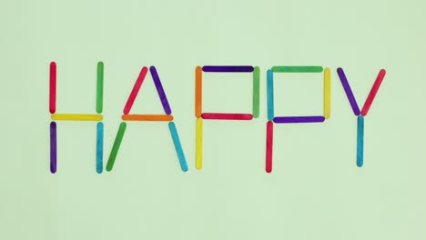 wooden sticks appear and write happy word. stop motion