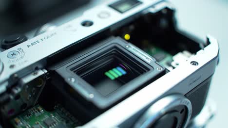 detailed examination of a camera's interior mechanism and components in two sequential frames, highlighting the sensor and circuitry of the device.