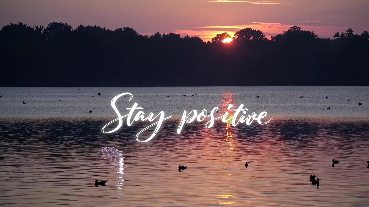 Tramonto sereno su un lago con anatre e testo ispirazionale