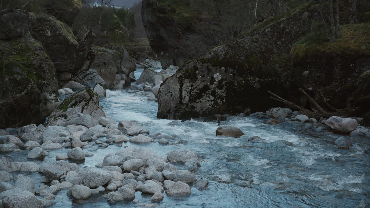 Il fiume scorre calmo tra le rocce in una fredda giornata invernale
