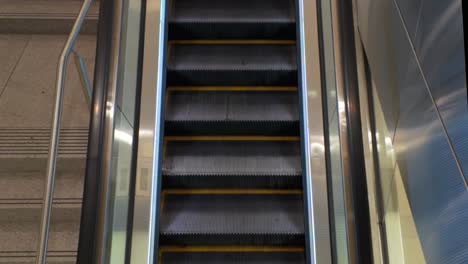 an interior shot of stairs next to a moving escalator