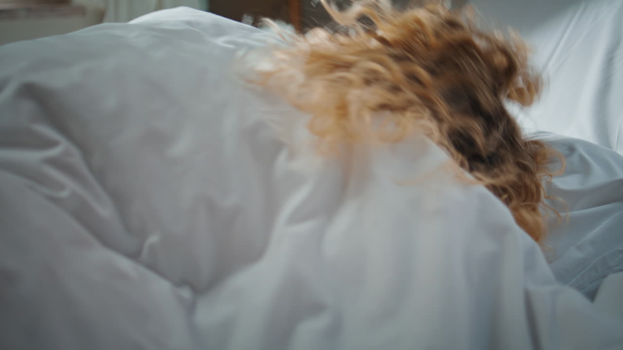 Awake woman stretching bed in morning sunlight. Closeup restful model dreaming