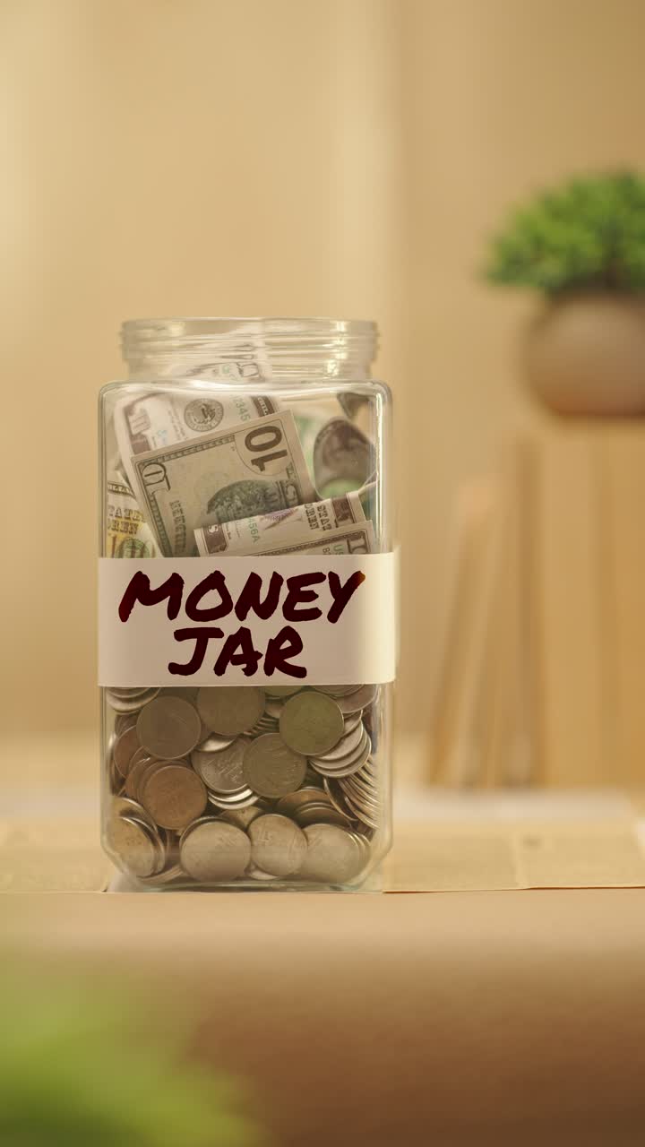 VERTICAL VIDEO OF PERSON SAVING MONEY FOR MONEY JAR