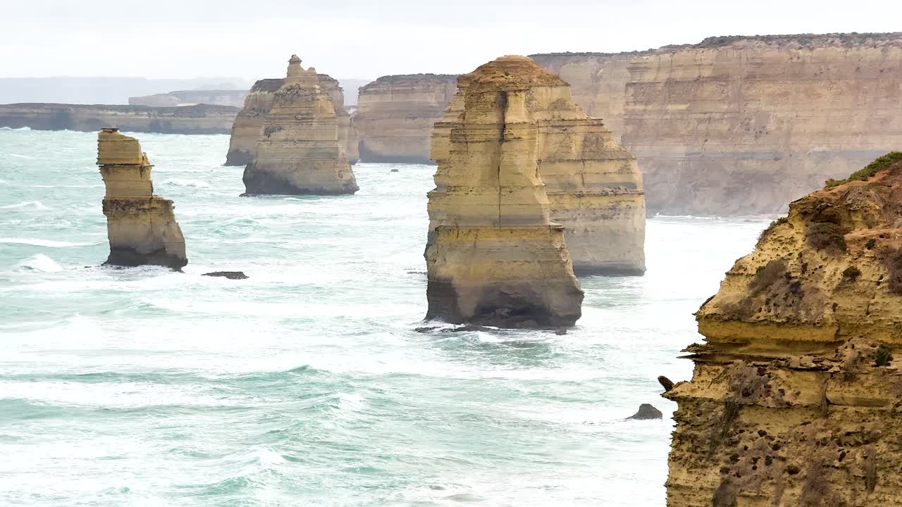 Stunning coastal rock formations with dynamic ocean waves under soft, natural lighting at Port Campbell, Australia