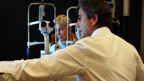optometrista explicando el informe de la vista en la pantalla 4k