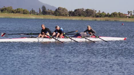 four senior caucasian men and women in rowing boat resting