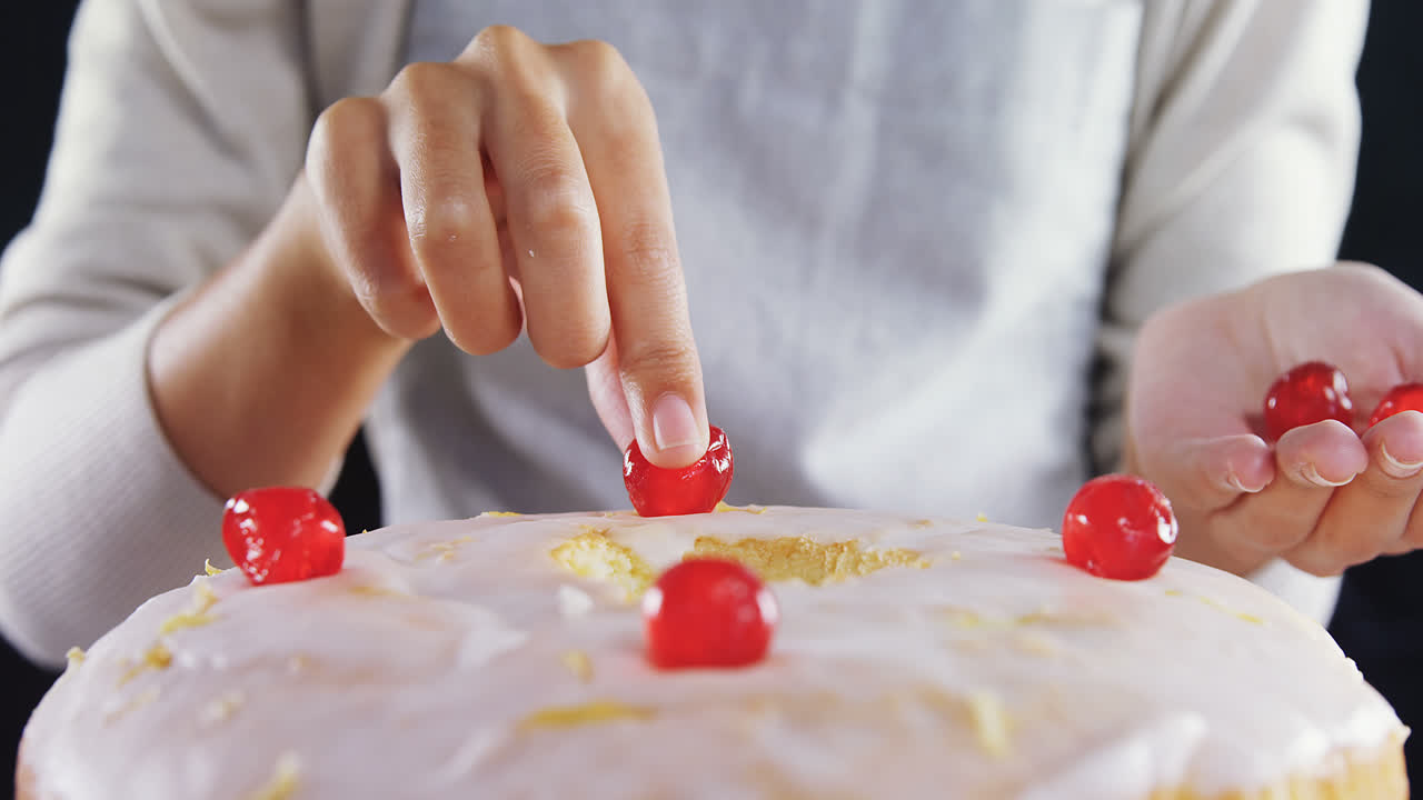 mujer cubriendo un pastel recién horneado con cereza 4k
