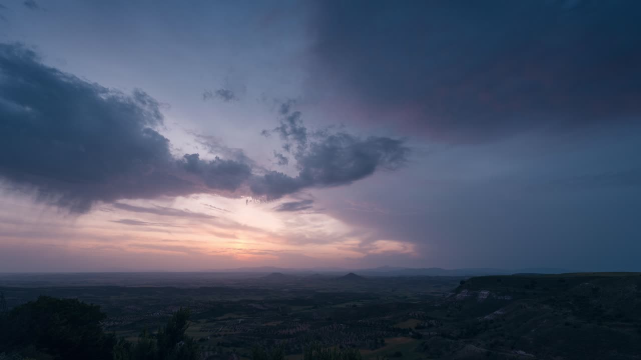 Warm sunset over La Alcarria plains with dramatic mammatus clouds and colorful sky, seen from a scenic viewpoint in rural Spain