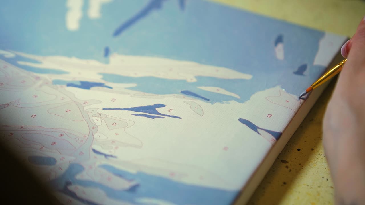 캔버스 템플릿에 밝은 회색 아크릴 페인트로 페인트 브러시를 들고 그림을 그리는 클로즈 업 여성 아티스트 손, 슬로우 모션 샷 닫기