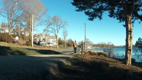 man walking alone by the water side with beautiful blue sky