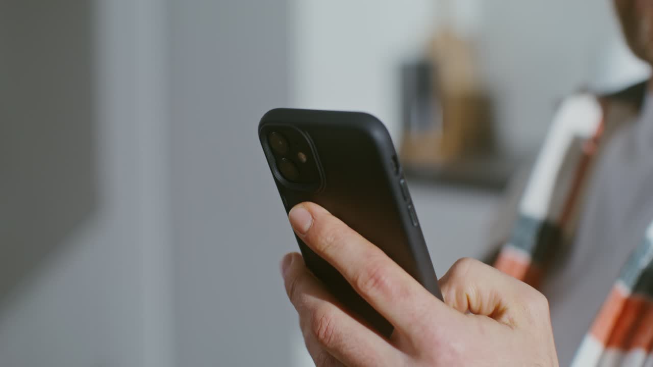 Persona che usa uno smartphone mentre beve caffè