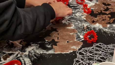 Up-close-cutting-gingerbread-cookie-dough-into-shapes-for-Christmas-celebration