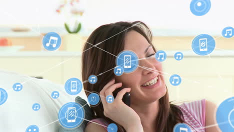 Animation-of-network-of-connections-with-icons-over-caucasian-woman-talking-on-smartphone