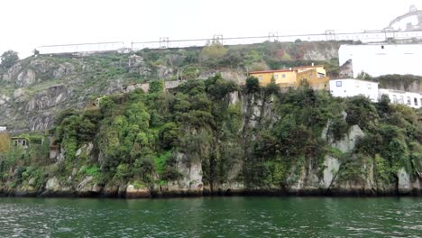 Exploring-Douro-River-by-boat,-Mosteiro-da-Serra-do-Pilar-over-the-mountainous-area