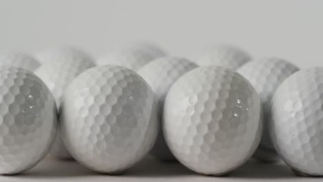 Nahaufnahme-Von-Golfbällen-Auf-Weißem-Hintergrund,-Kopierraum,-Zeitlupe