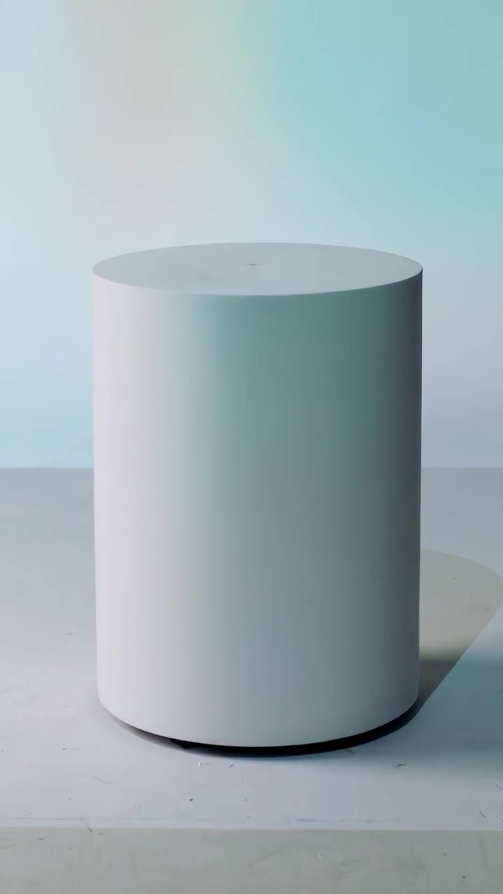 Video verticale: Luci rotanti che proiettano una sfumatura di colore su un piedistallo bianco in studio.