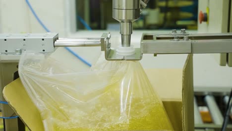 close-up shot of finishing the packaging of kernel palm oil with an automatic filling machine and automatic conveyor belt